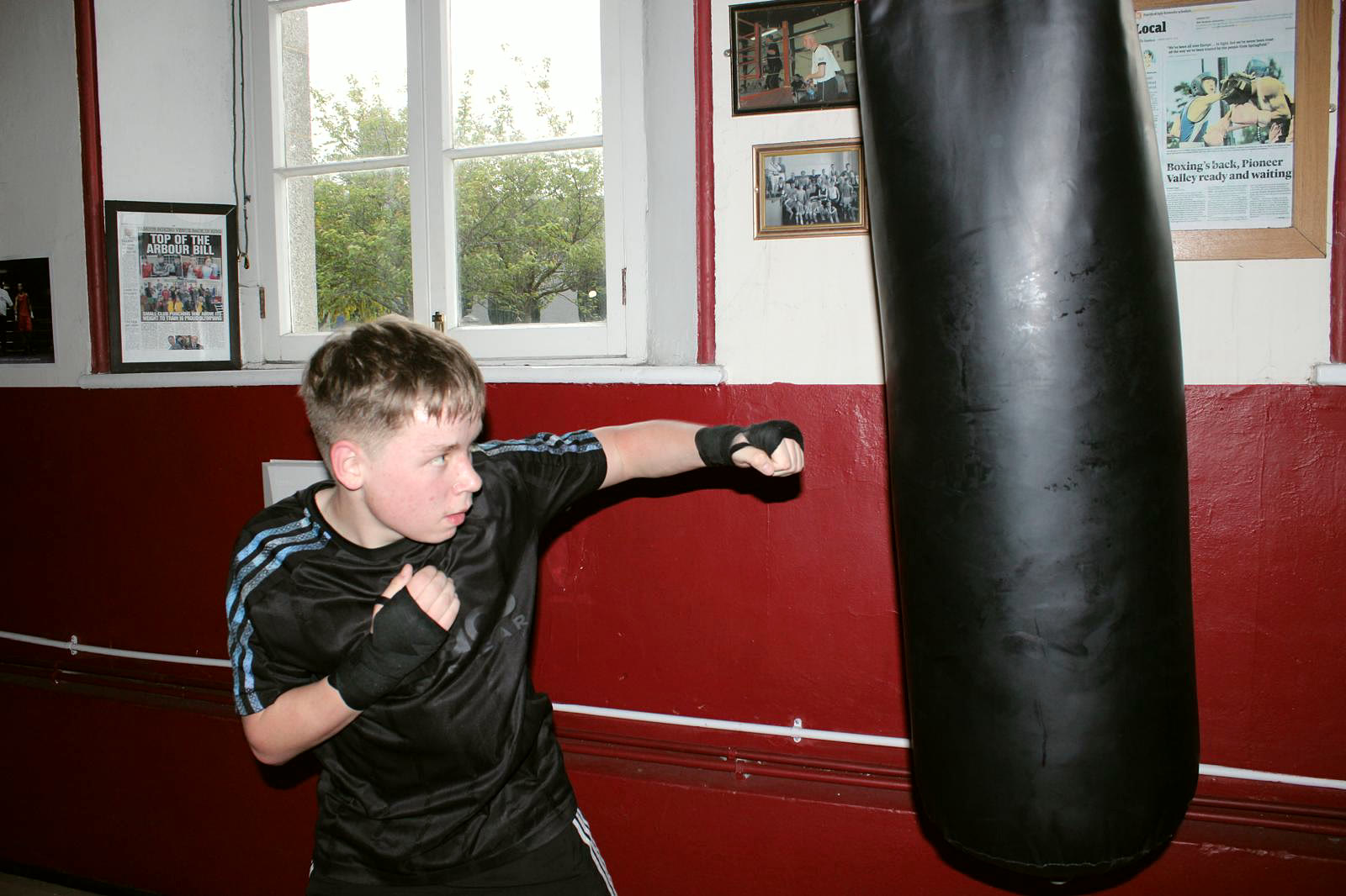 A teenager working the heavy bag